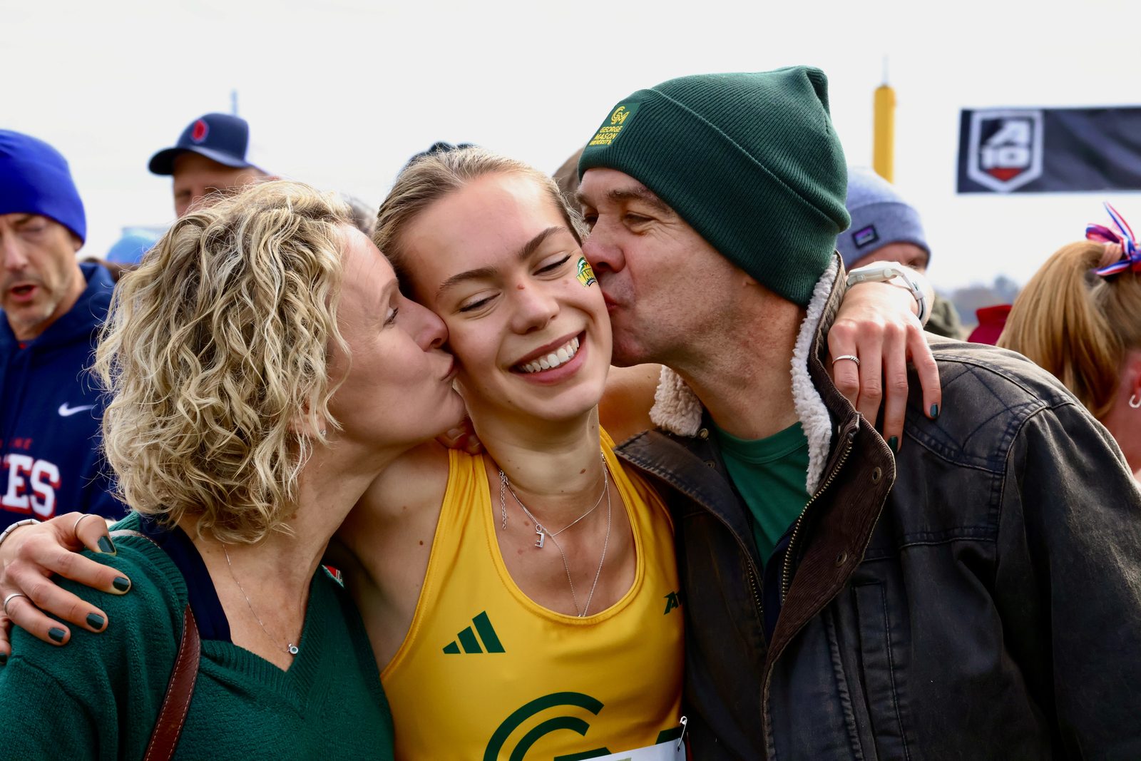 A heartfelt moment, parents embracing their daughter at the finish line after her race. 