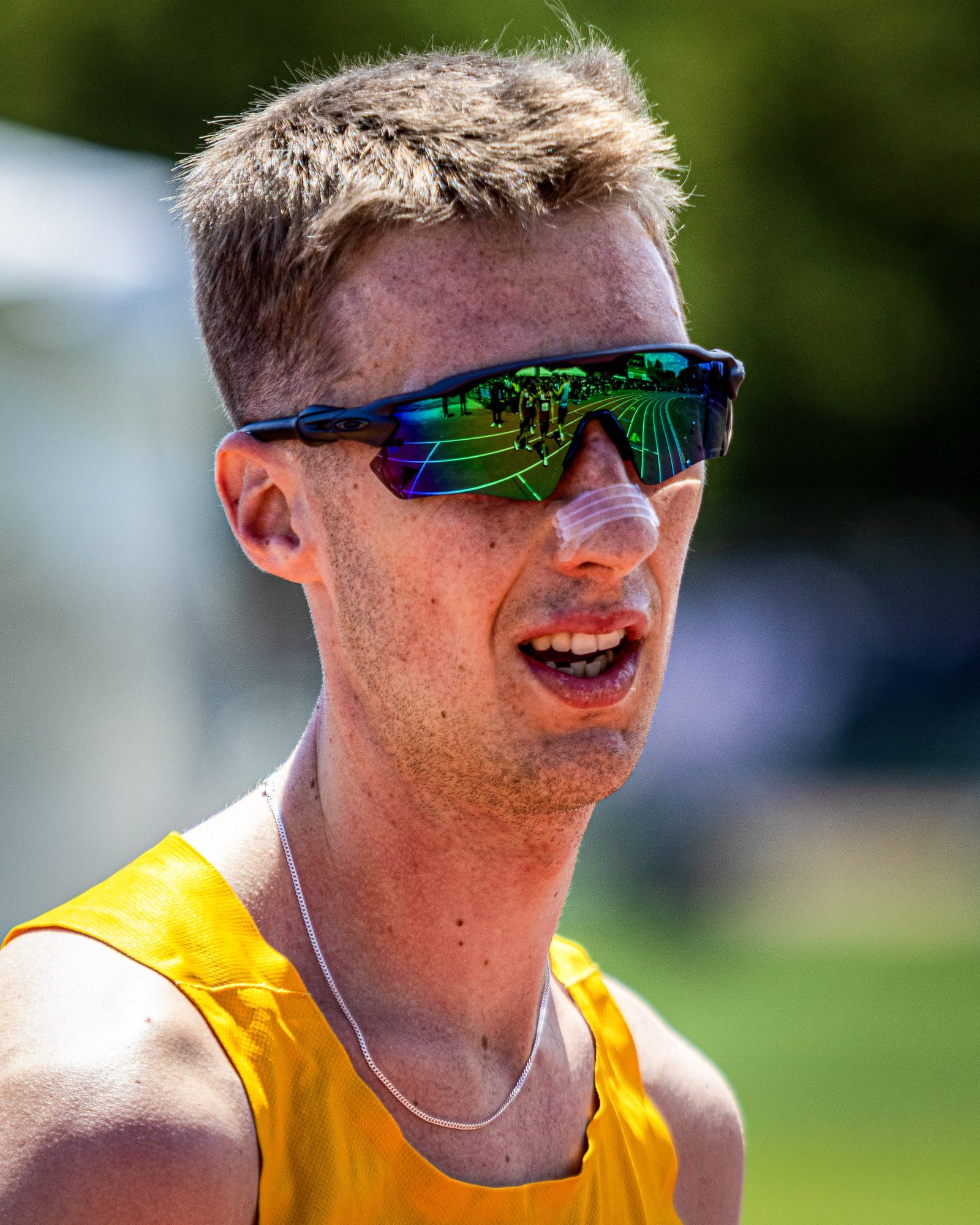 Tight portrait of a runner wearing mirrored sport sunglasses. 