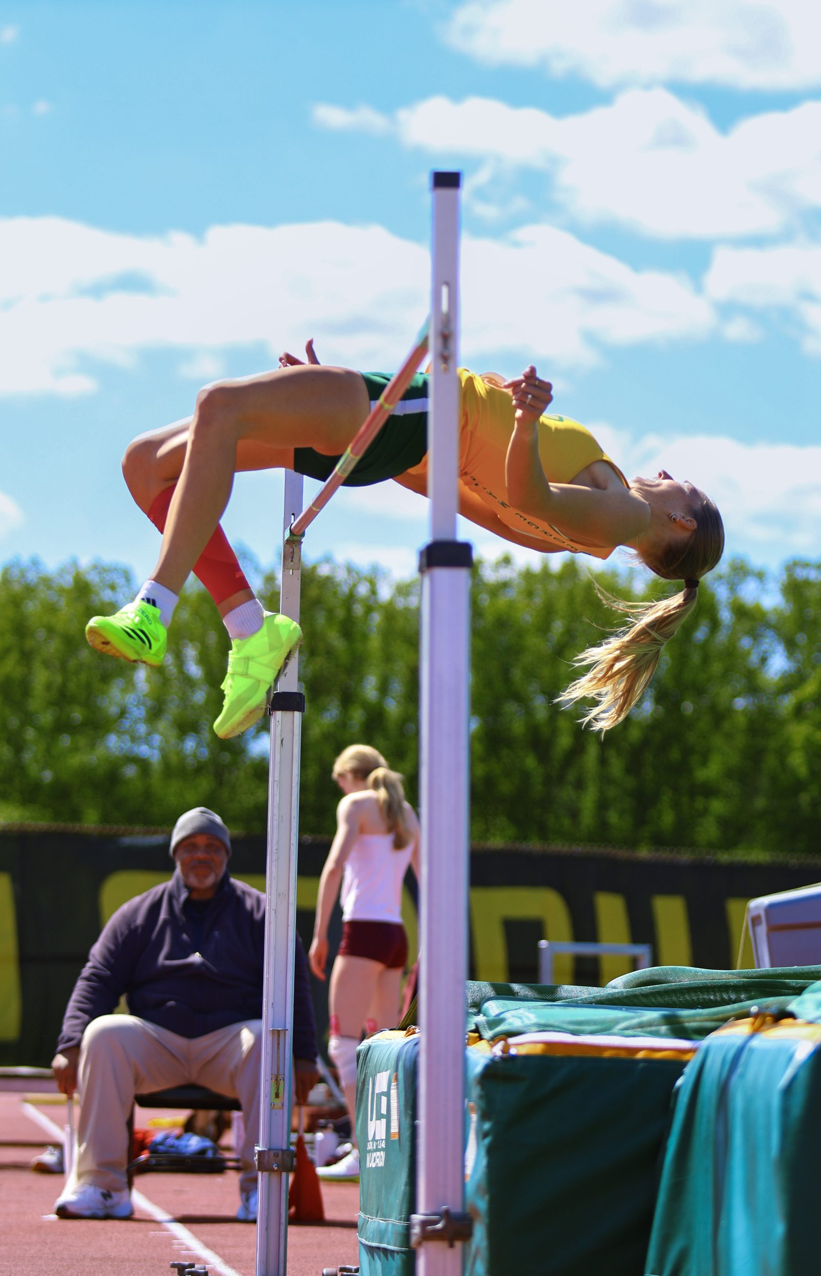 Female high jumper arching backward over the bar. 