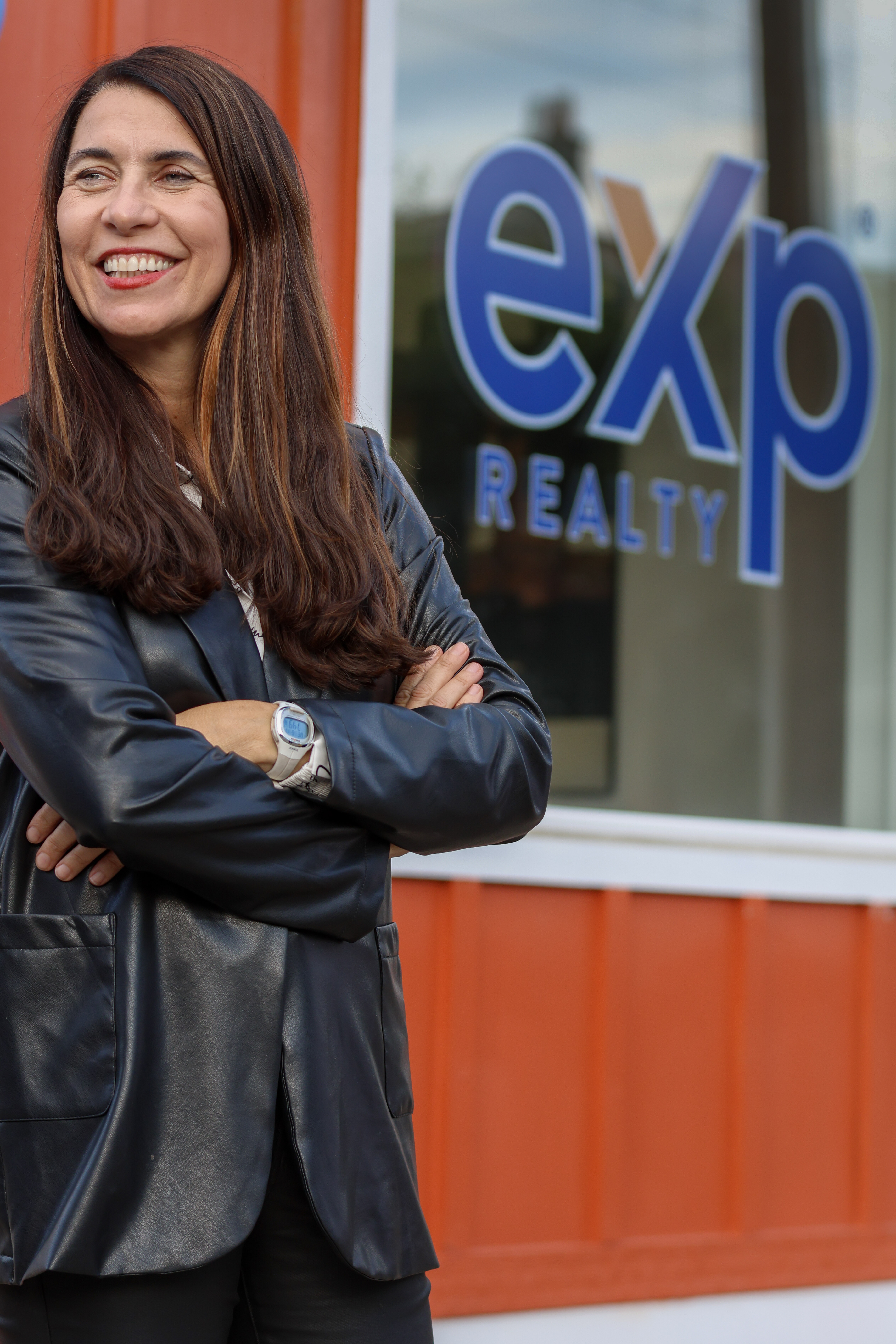 Business owner overlooks a crowd in front of her new location opening.