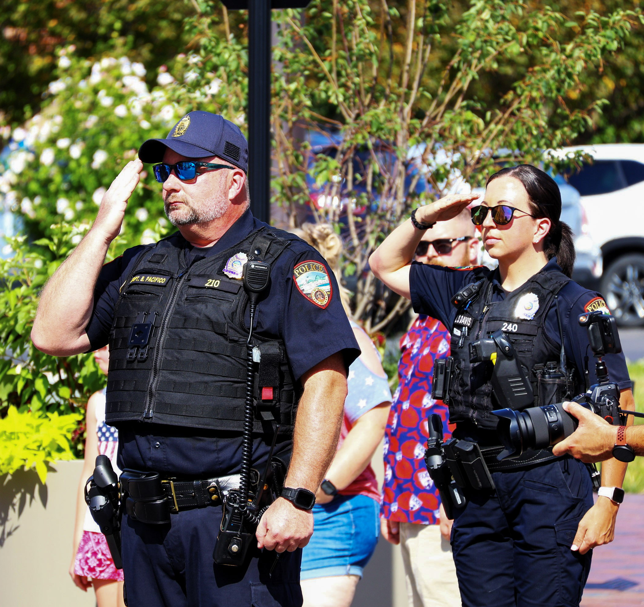 Two police officers stand at attention during the national anthem during July 4th celebrations.